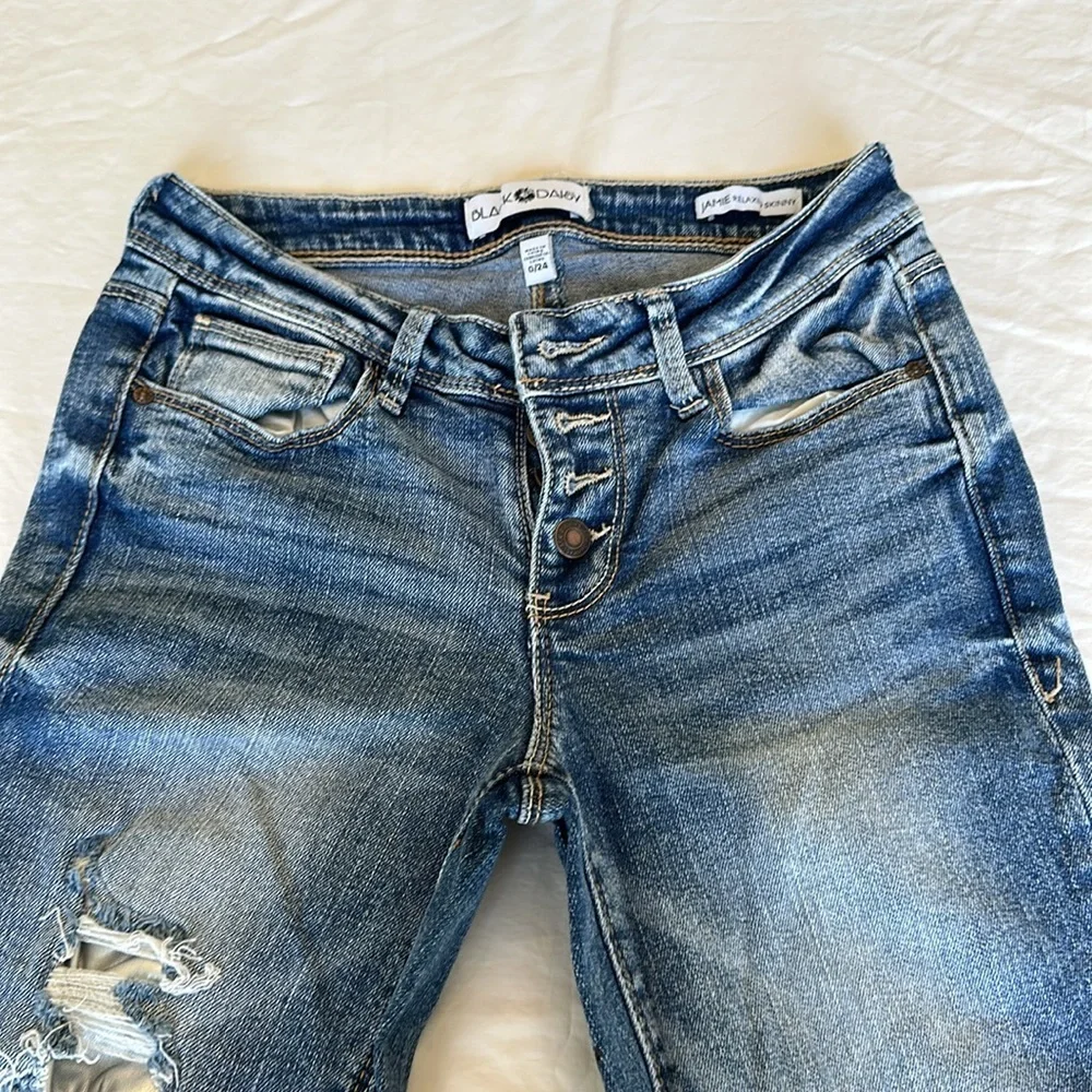 Black Daisy jeans with gem embellishments and rips w/ silver lining 26.5” inseam